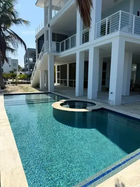 Pool and round spa with modern three-story stilt house